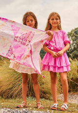 Above knee tiered pink cotton birthday dress with pompoms