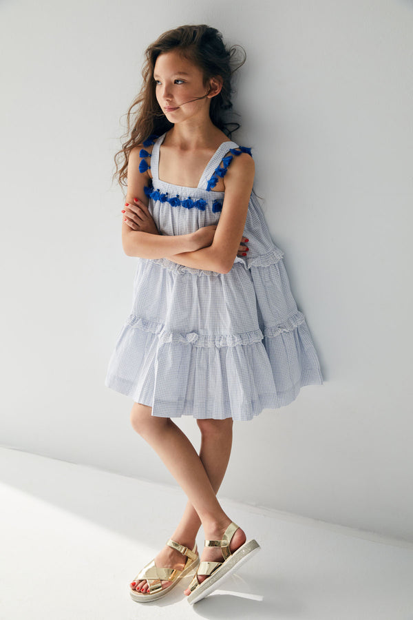 Knee length white and blue checkered cotton birthday dress with tassels