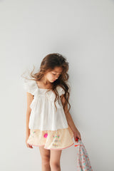 Cream linen flared shorts with pompoms